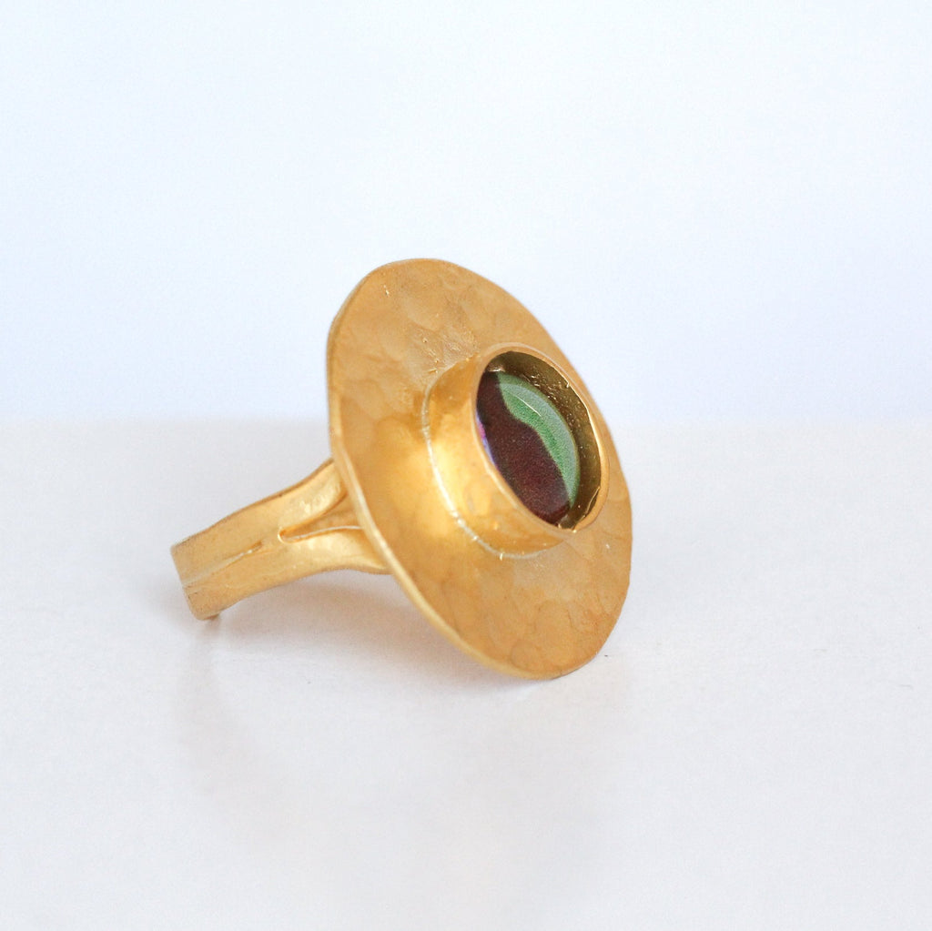Gold ring with a green gemstone on a white background